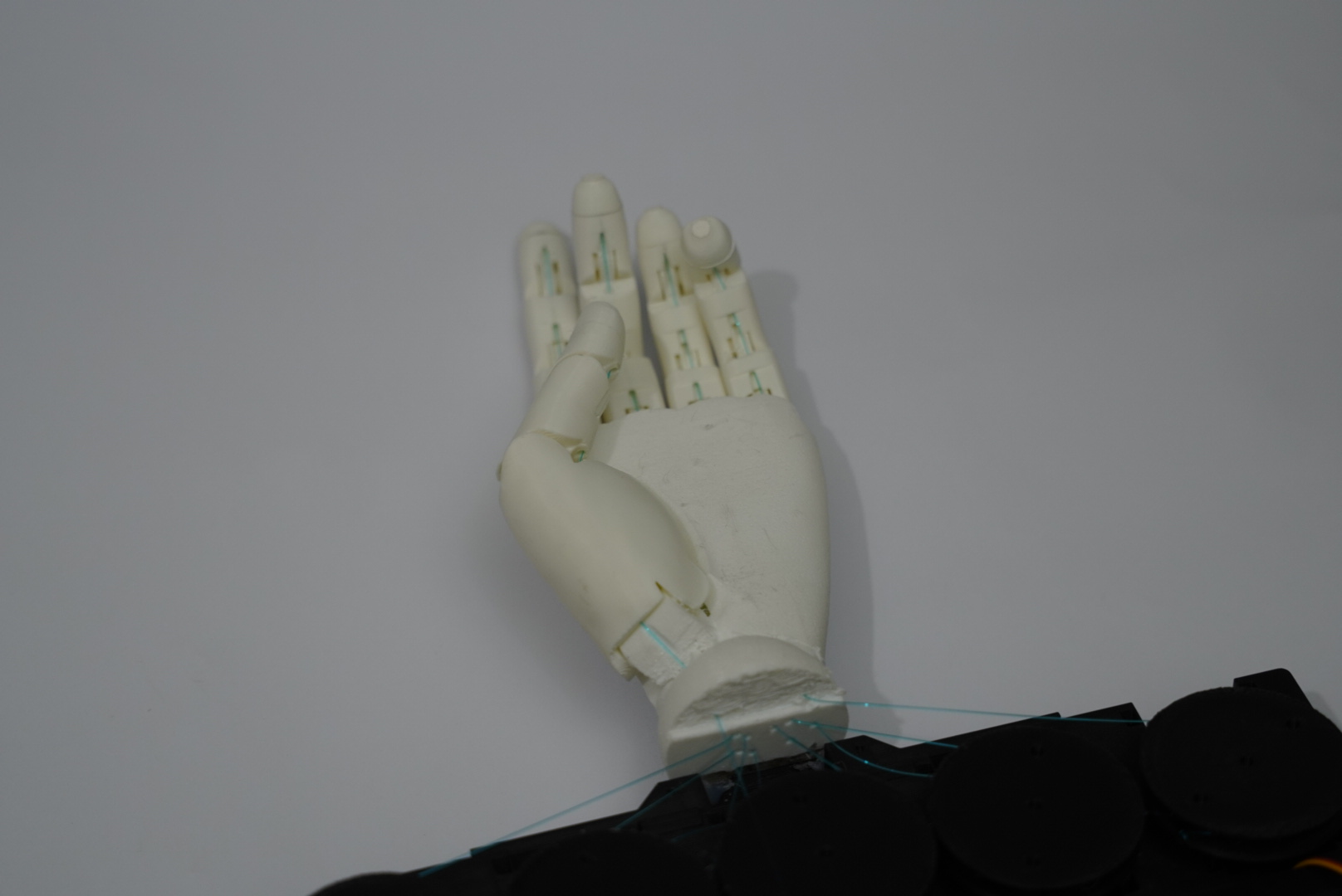 An open prosthetic hand prototype photographed on a work surface